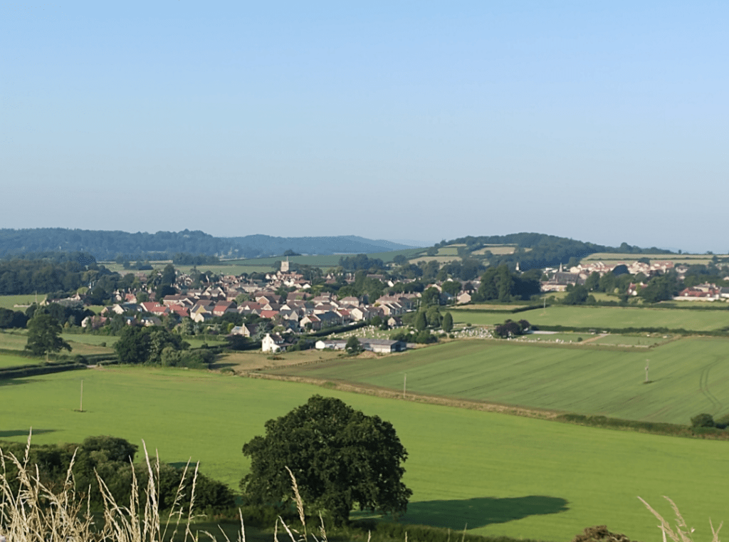 A summer view over an English rural landscape with a village amidst fields and woods